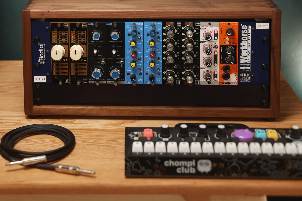 Walnut studio rack with a coiled instrument cable on a studio desk