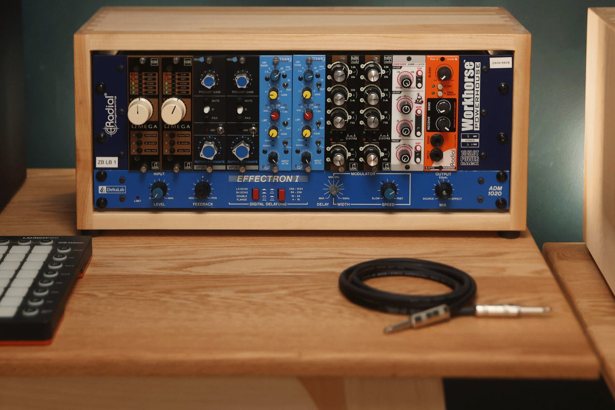 Maple studio rack with a coiled instrument cable on a studio desk